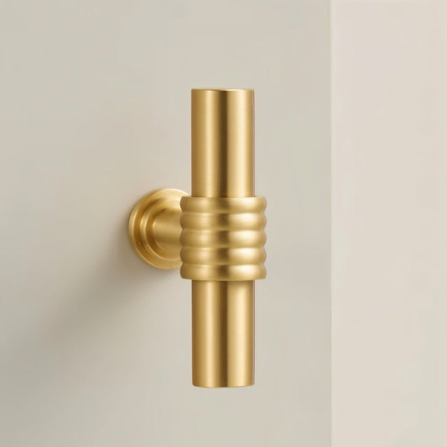 "close-up of a brass knob with ribbed circular design"