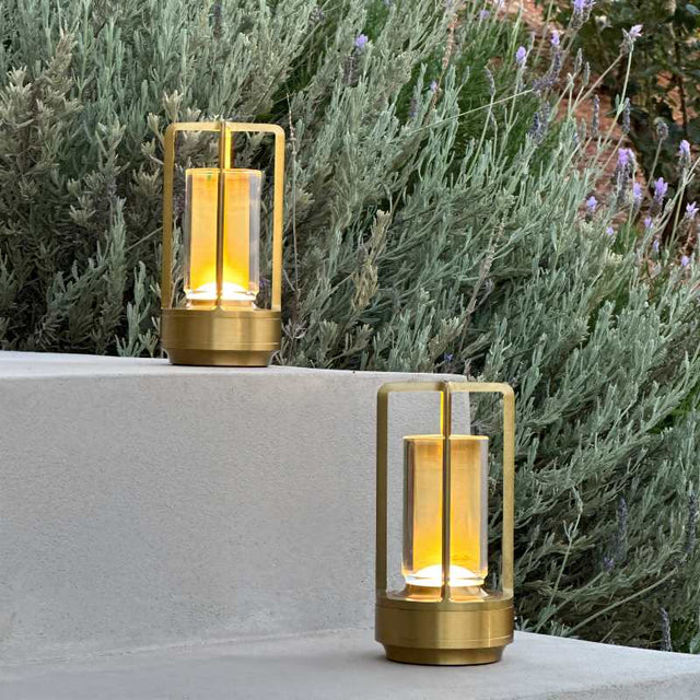 Orena Table Lamp - Sleek Rechargeable Indoor/Outdoor Light in gold, placed on outdoor steps with warm glow for garden or patio lighting.