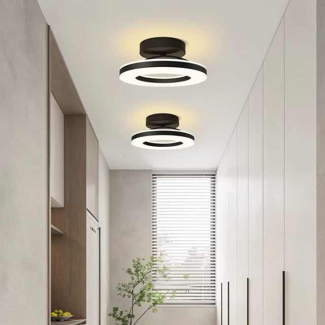 "Two modern circular ceiling lights with black dual-ring design in a contemporary hallway."