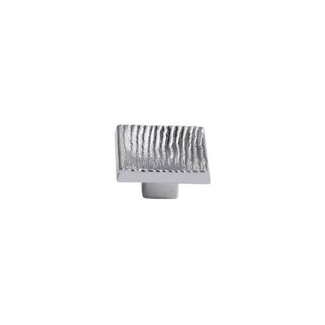 "Studio shot of a single polished nickel square cabinet knob with a ridged, textured surface on a white background."