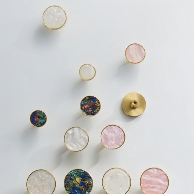 "Round brass knobs with intricate shell inlays, adding a touch of modern elegance to cabinets and drawers."
