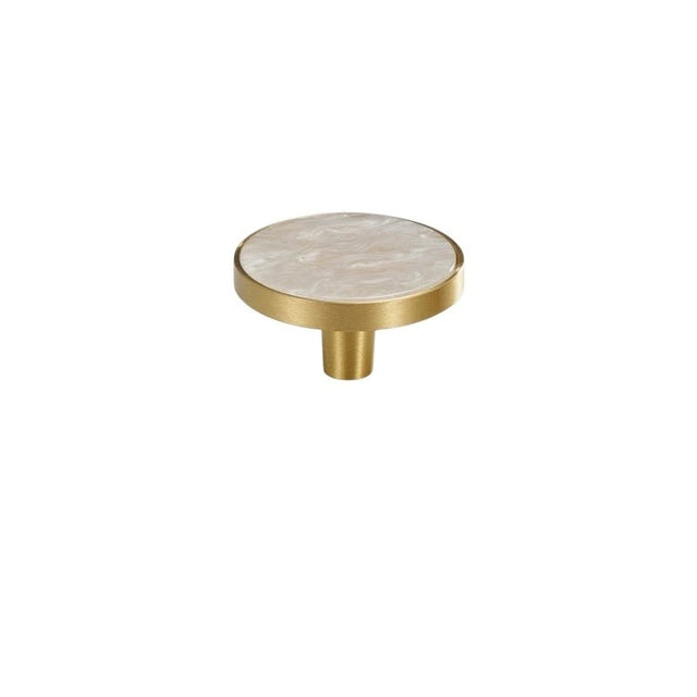 "Top view of a round brass cabinet knob with a white shell inlay, isolated on a white background."