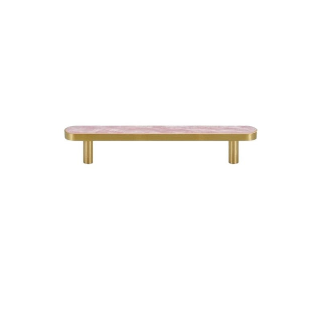 "A modern brass pull bar with a pink shell inlay, isolated on a white background."