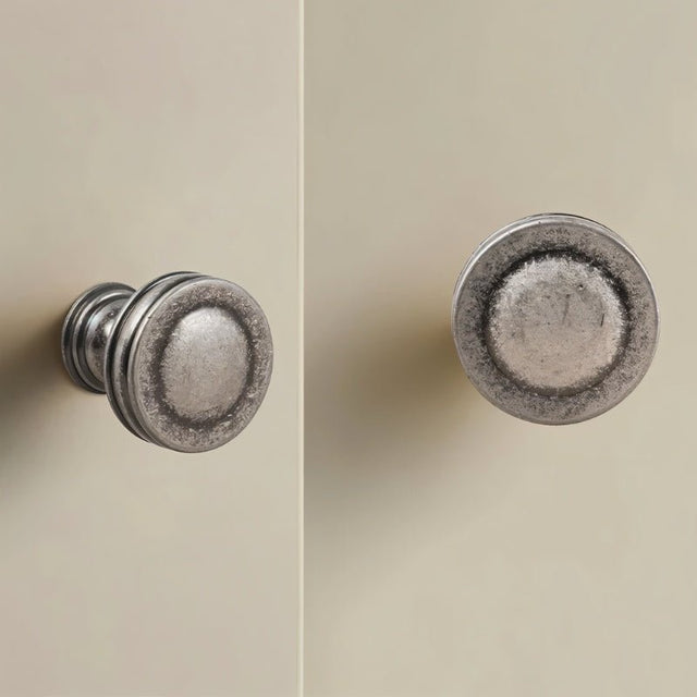 "Vintage-inspired layered brass knobs with a distressed finish on cabinet doors, showcasing their classic design."