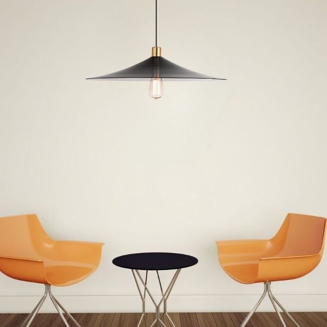 "Raida pendant light with a sleek black conical design, hanging over a modern living room setup featuring orange chairs and a black table, offering a stylish and inviting atmosphere."