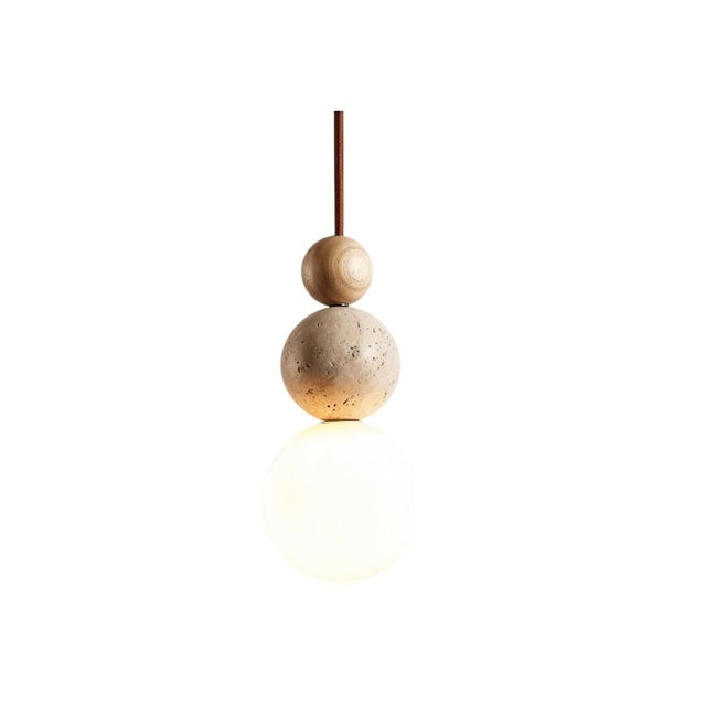 "Sculptural pendant light with stacked travertine, wood, and metal elements, featuring a frosted glass diffuser, isolated on a white background."
