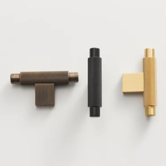 Knurled brass knobs and pull bars in antique, black, and gold finishes, showcasing their industrial design and functionality for modern spaces."