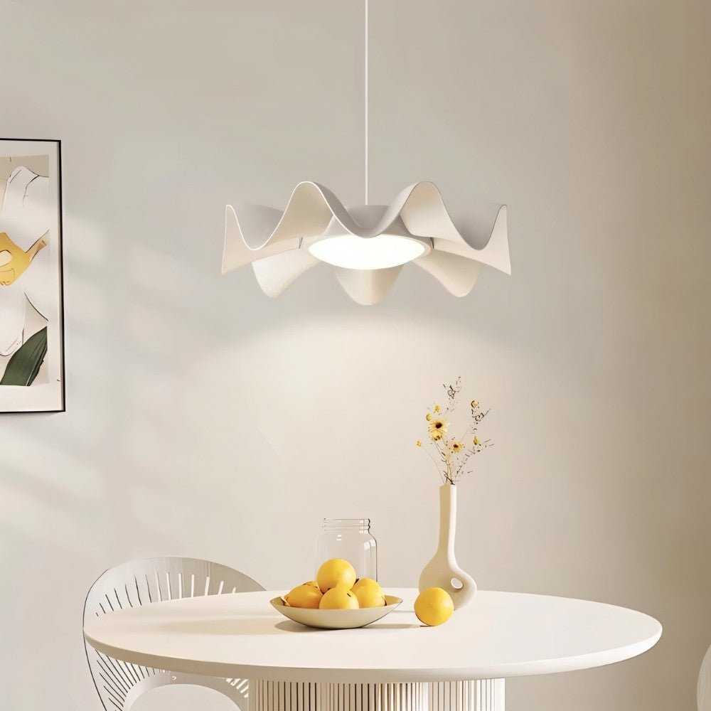 "Sculptural pendant light with a wave-like frame and acrylic diffuser illuminating a modern dining room with a soft glow."