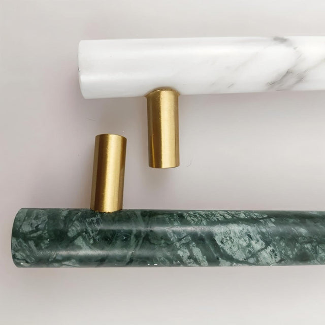 "Close-up detail of marble and brass pull bars, showcasing the texture and elegant joinery."