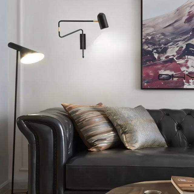 "Black and gold adjustable arm bedside reading lamp mounted on a living room wall."