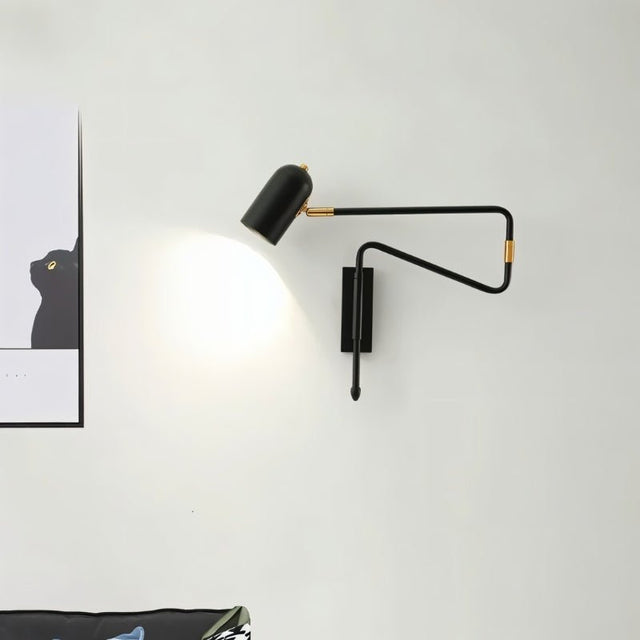 "Black and gold adjustable arm bedside reading lamp mounted on a white wall."