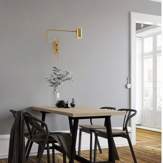 "Gold adjustable arm bedside reading lamp mounted on a dining room wall."