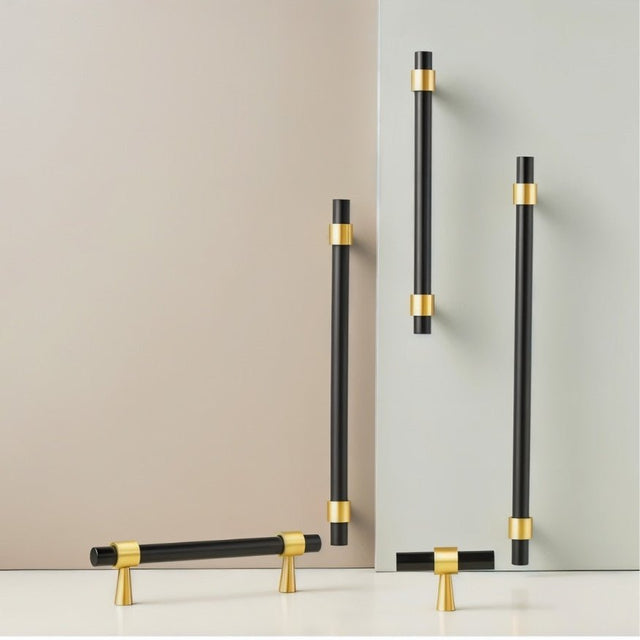 "Set of black and gold brass pull bars with cylindrical design and subtle accents, arranged on a grey and white surface."