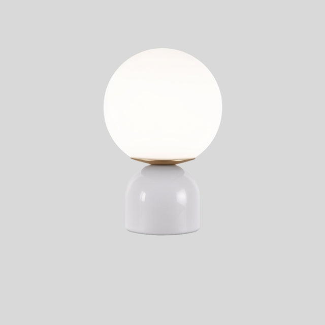 Sibwa Table Lamp with glossy white base and glowing globe, suitable for contemporary bedroom or living room lighting.