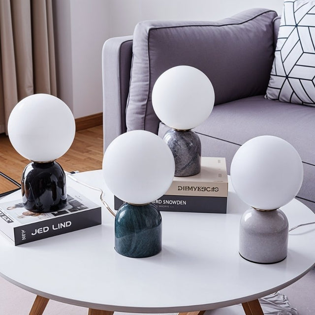 Collection of Sibwa Table Lamps with various marble and metal bases on a round coffee table, showcasing modern lighting options.