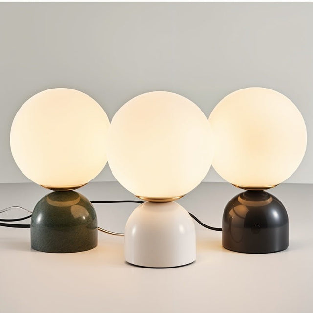 Three Sibwa Table Lamps in green, white, and black bases glowing warmly, highlighting modern lighting versatility for interiors.