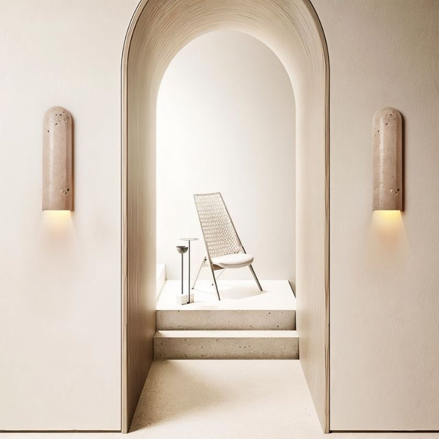 "Solon travertine wall lamp casting ambient light, enhancing a minimalist space with natural textures and subtle variations in the travertine surface."
