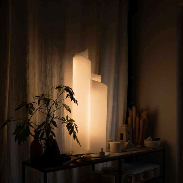 Stellora Table Lamp emits soft ambient light in a dim room, showcasing its acrylic spiral design for modern bedroom or living room lighting.