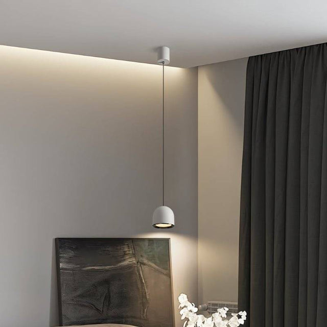 White Sterna Pendant Light hanging in a modern living space with soft lighting, highlighting its dome-shaped aluminum fixture.