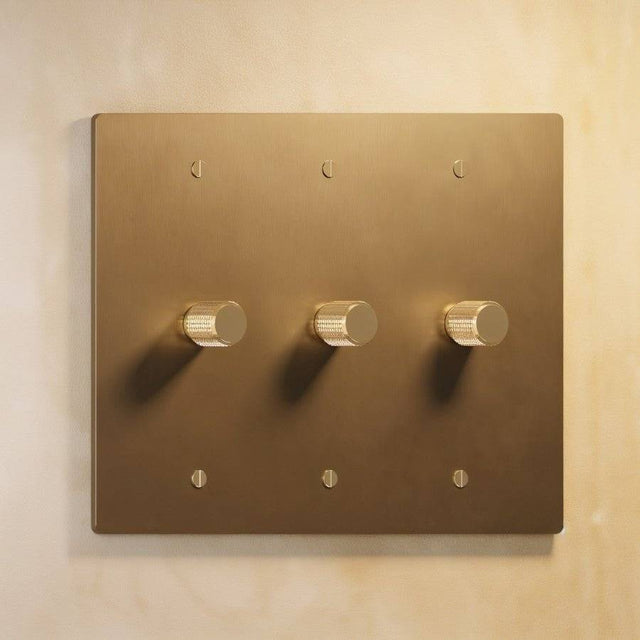 Three-gang Brass 3-Way Rotary Dimmer Switch with elegant brass finish, designed for controlling multiple lighting zones in one panel.