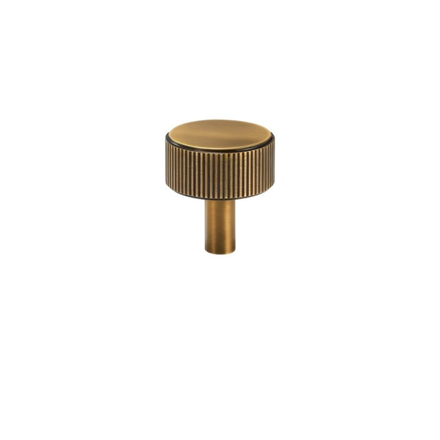 "A modern brass knob with a sleek ribbed texture, suitable for cabinet doors and drawers in modern and transitional interiors."