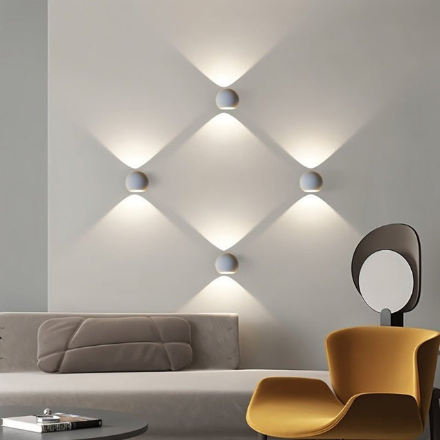 "Set of spherical gypsum and aluminum wall lamps, casting soft, multidirectional light, enhancing the modern interior of a living room."