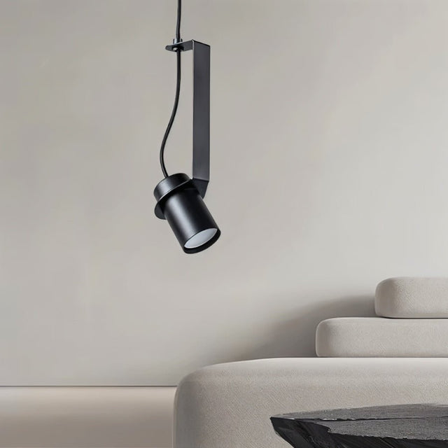 "A directional pendant light with a cylindrical shade, suspended in a modern living space, providing focused illumination."
