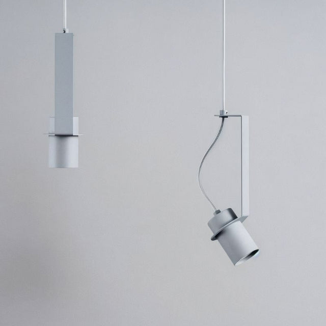 "Two grey pendant lights, one straight and one oblique, showing their different orientations and minimalist design."