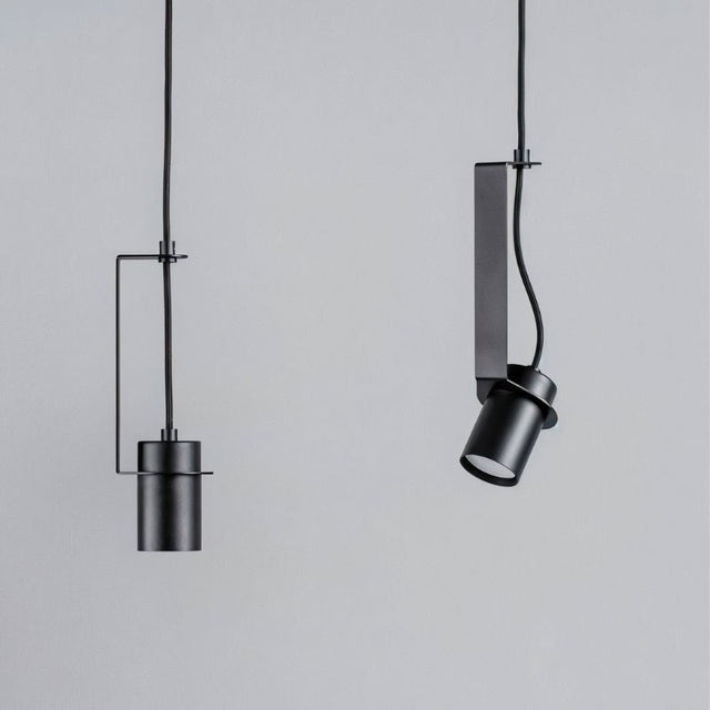 "Two pendant lights, one straight and one oblique, with cylindrical shades, demonstrating their different orientations."