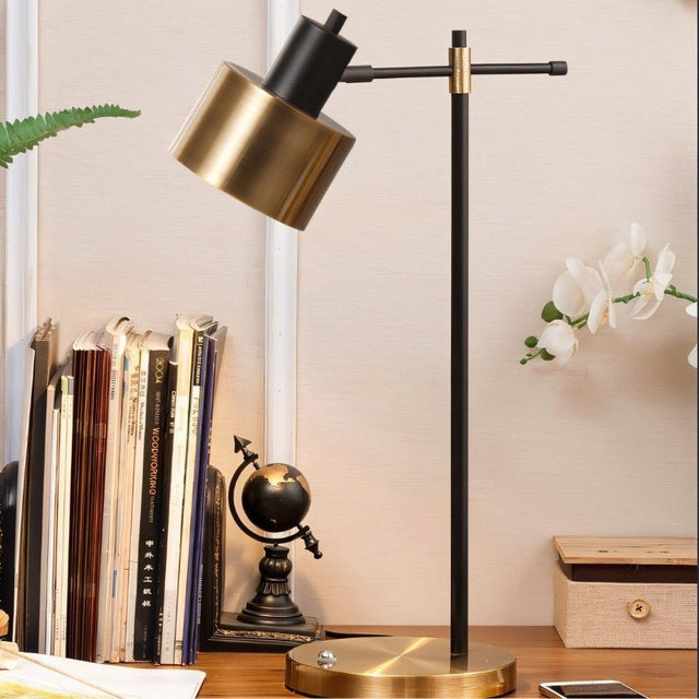 "Iron and brass table lamp with a rotatable head, placed on a desk with books and globe, perfect for modern workspaces"