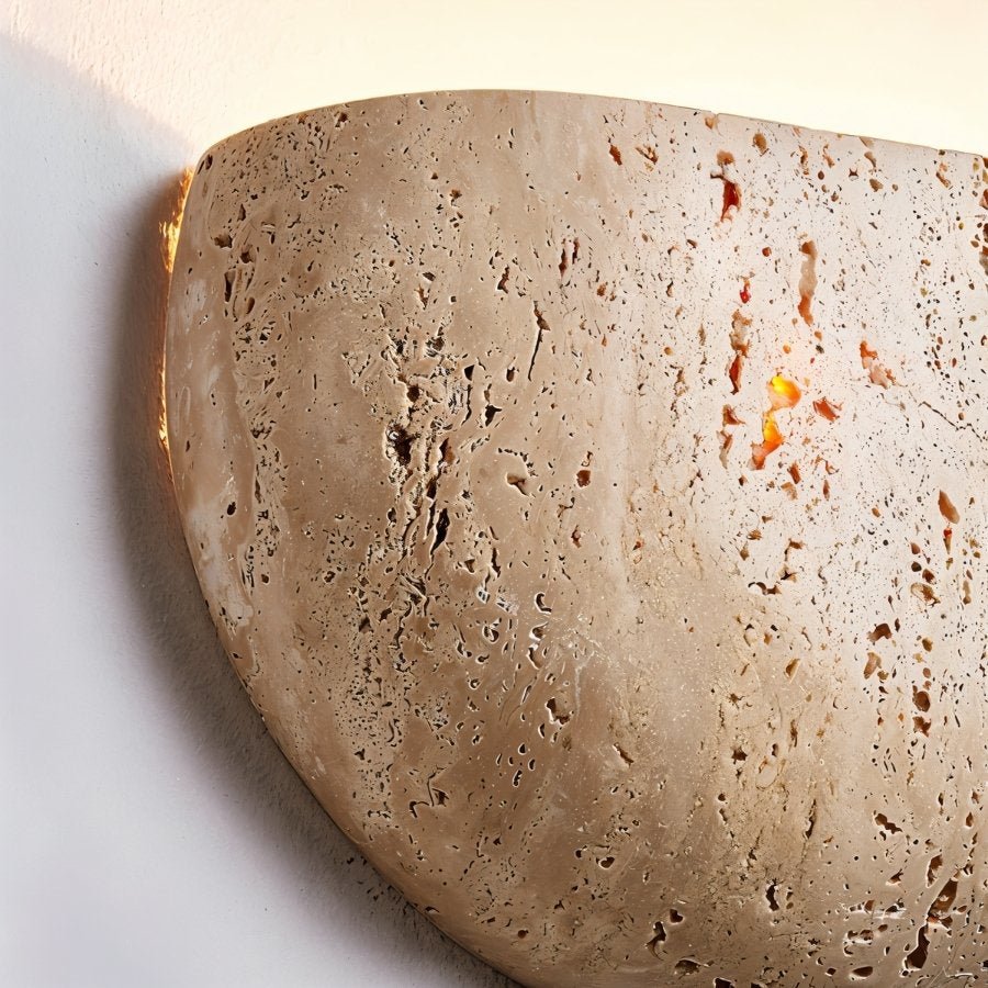 "Close-up of a travertine wall lamp, showcasing the natural stone texture and soft, warm glow."