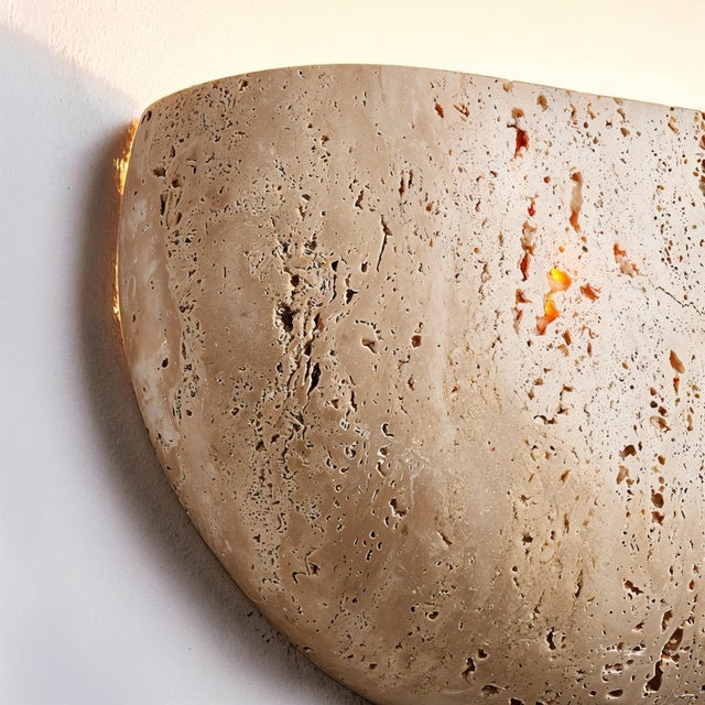 "Close-up of a travertine wall lamp, showcasing the natural stone texture and soft, warm glow."