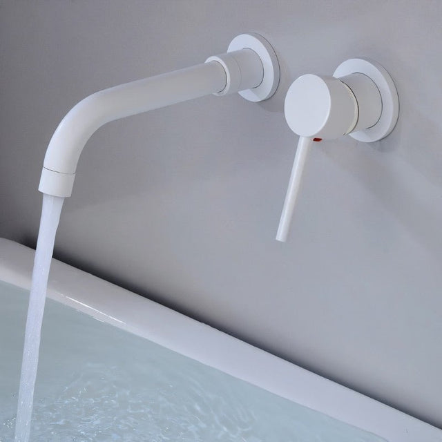 Matte white Vartay Bathroom Faucet with water running, wall mounted above a bathtub for a clean modern aesthetic.