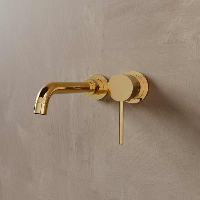 Close-up of Vartay Bathroom Faucet in polished gold, wall mounted with a sleek round handle and curved spout.