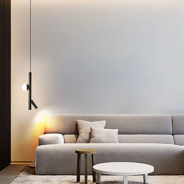 "A modern living room featuring a sleek iron and acrylic pendant light with cylindrical rods and a glowing orb accent, hanging above a gray sofa."