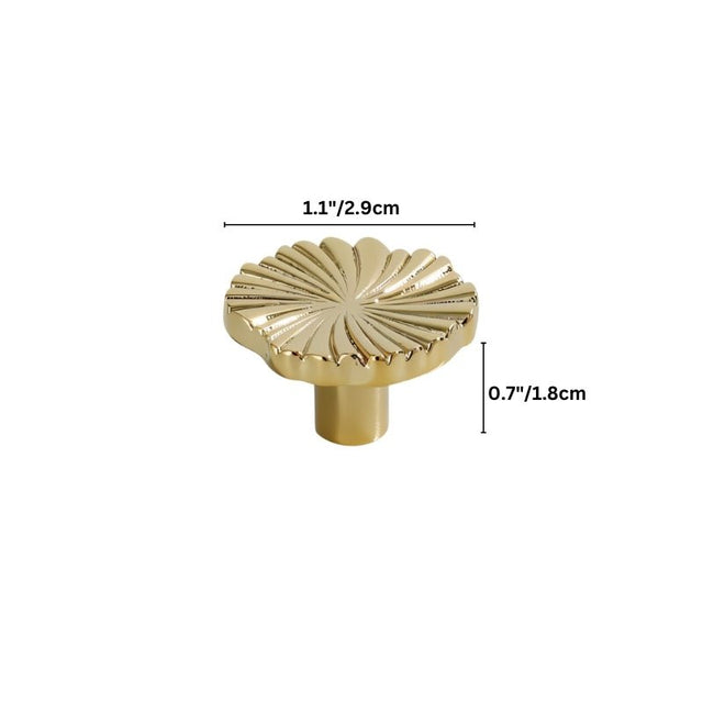 "Close-up of a gold brass drawer pull with a fan-shaped design, showing intricate details."