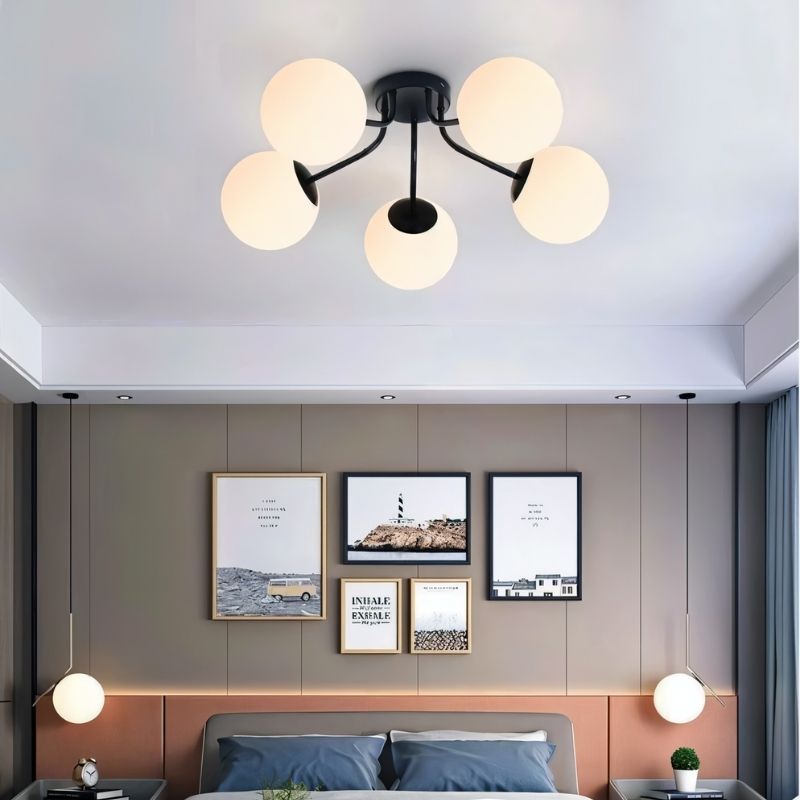 "A modern ceiling light with spherical glass shades in a bedroom interior."