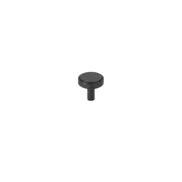 "A black faceted brass knob with a diamond-cut texture, isolated on a white background."