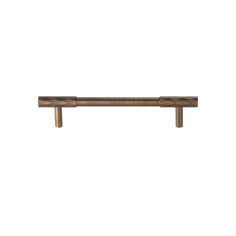 "An antique brass faceted pull bar with a diamond-cut texture, isolated on a white background."