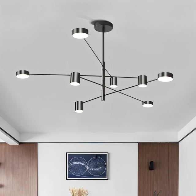 "A black chandelier with multiple arms extending in different directions, each with a small, round light at the end, shown installed on a white ceiling above a framed map."
