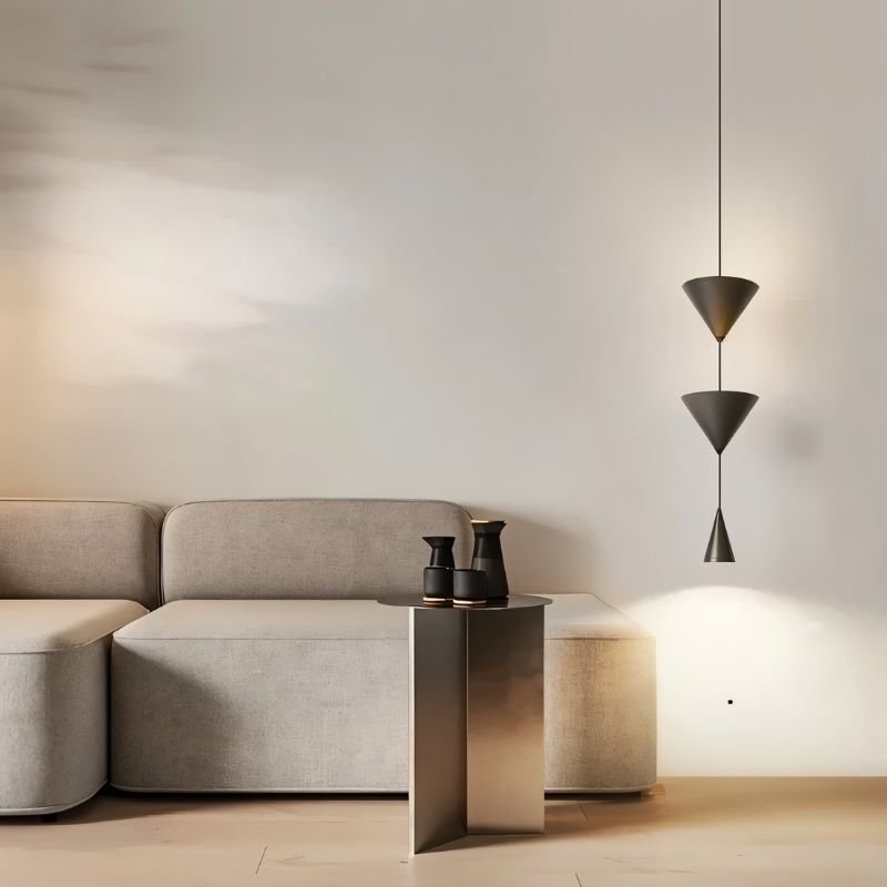 "Modern black pendant light with stacked conical shades providing a focused glow in a minimalist living room."