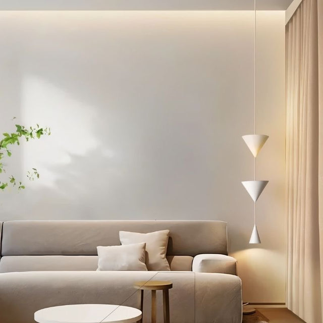 "Modern pendant light with stacked conical shades providing ambient lighting in a minimalist living room."