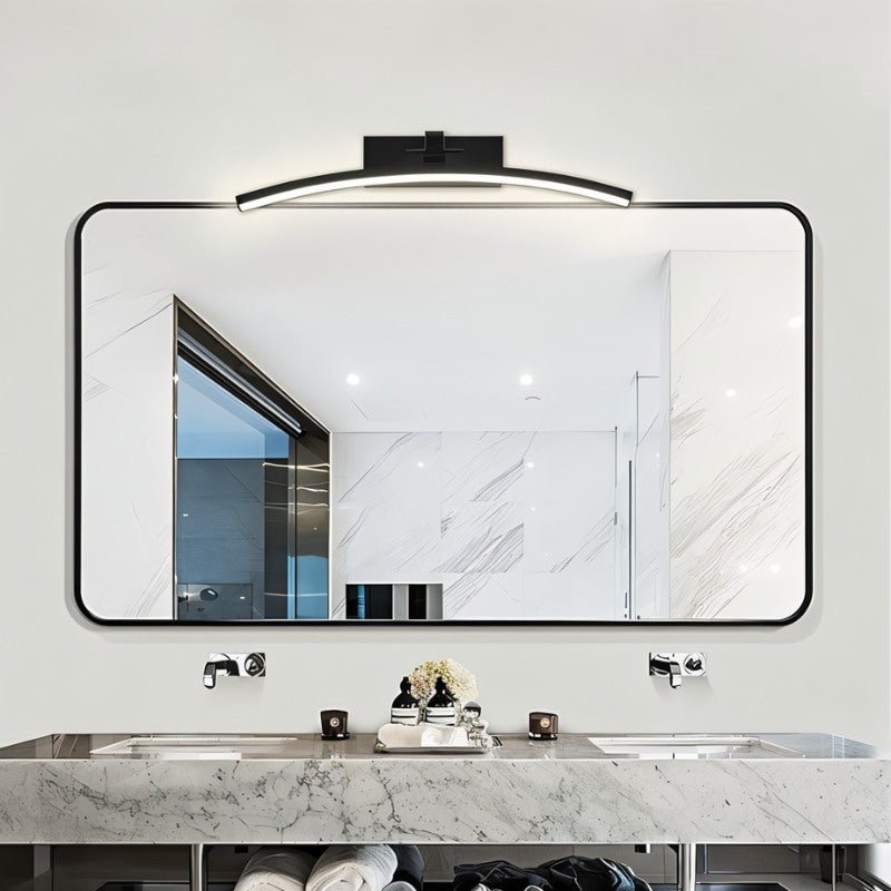 "A modern, curved LED wall lamp illuminating a bathroom mirror over a double sink vanity."