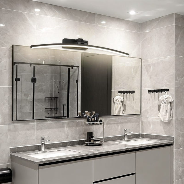 "A modern, curved LED wall lamp illuminating a bathroom vanity with a double sink and mirror."