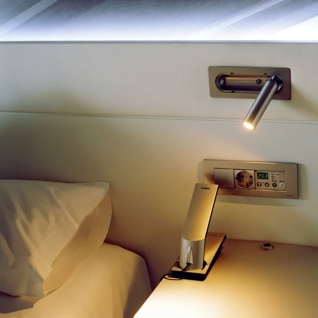 "Zarwa bedside reading lamp mounted on the wall, offering a sleek design with an adjustable spotlight for task lighting, made from durable metal and acrylic materials."
