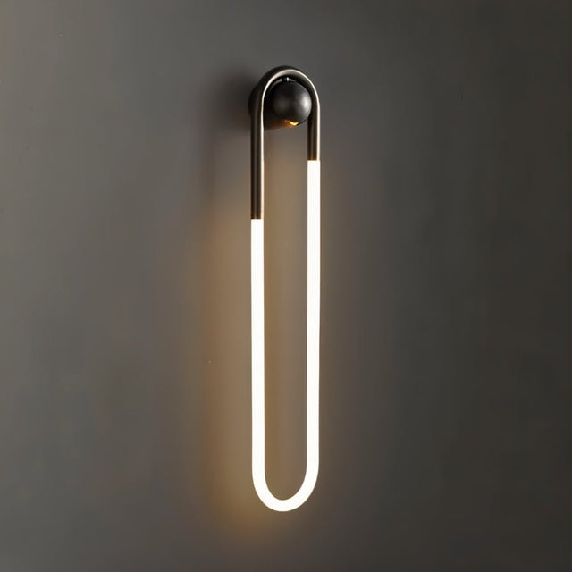 "A modern, minimalist U-shaped wall lamp with a black and brass finish, providing soft illumination."