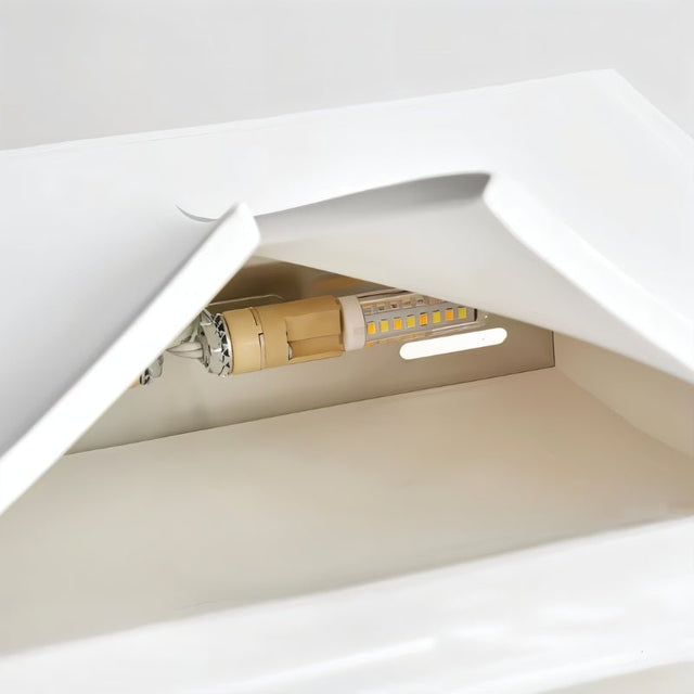 "A close-up view of the internal light source and components of a white trimless wall light."