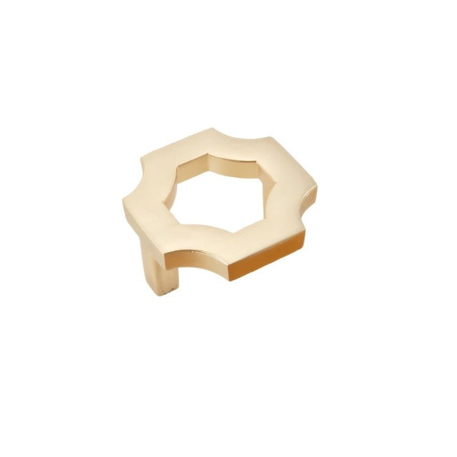"A brushed gold, geometric knob with sharp, angular edges, made of zinc alloy, isolated on a white background."