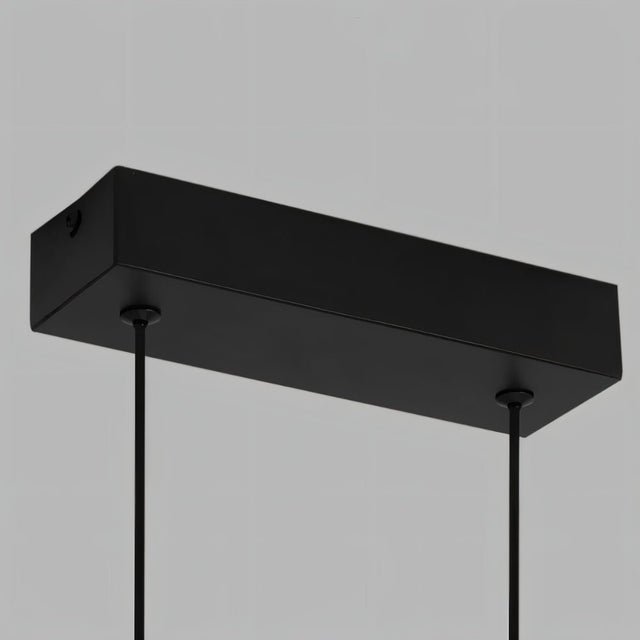 "Close-up detail of the rectangular canopy of a modern LED pendant light with thin suspension cables."