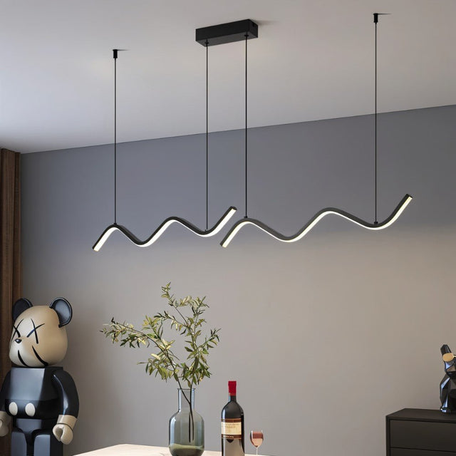 "A modern LED pendant light with fluid, wave-like bars, illuminating a dining area with contemporary decor and art pieces."
